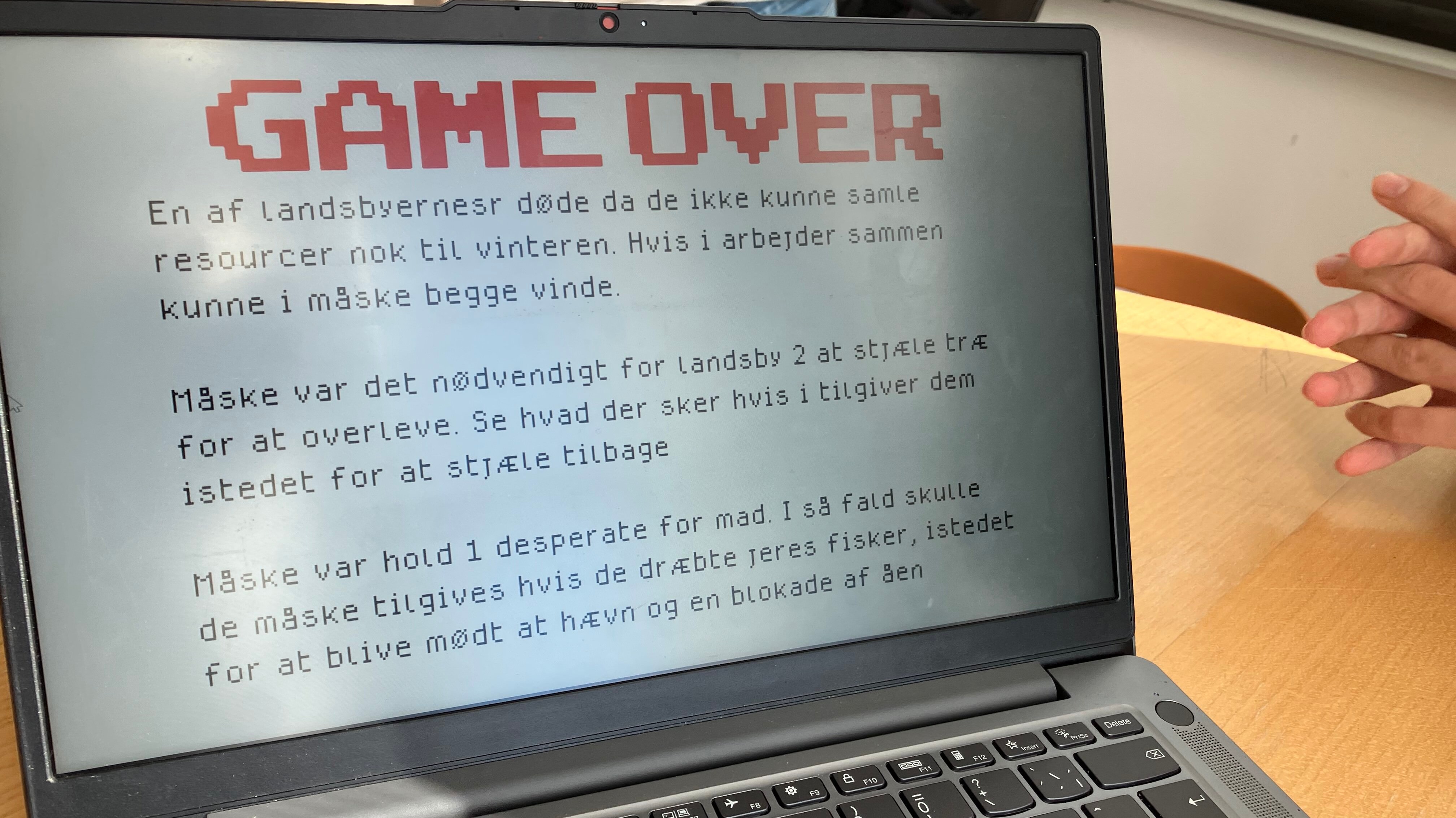 En computerskærm står på et bord med teksten Game Over