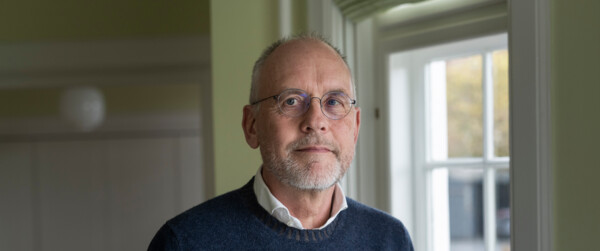Portræt af biskop Henrik Wigh-Poulsen stående ved vinduet på sit kontor
